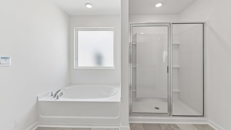 primary bathroom with walk in shower and dual vanity sinks