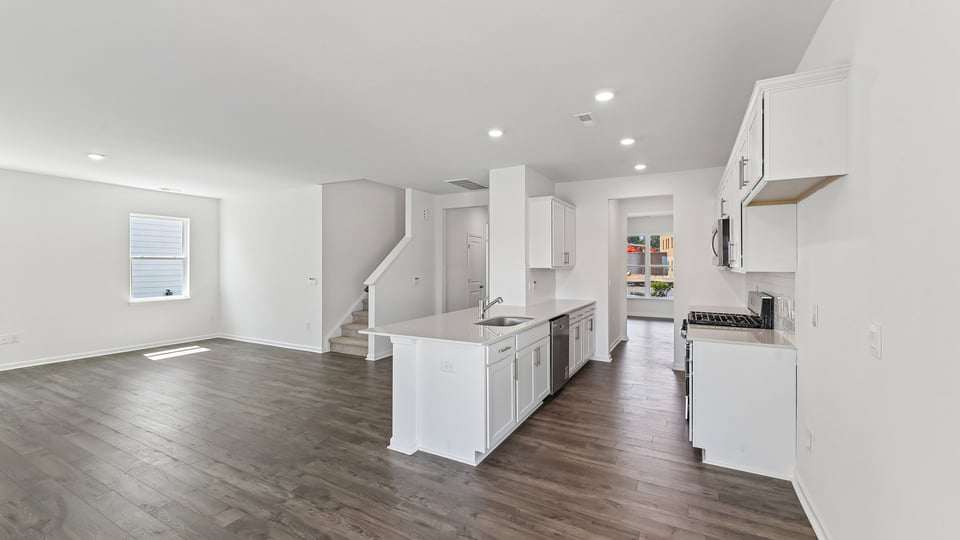 kitchen with quartz counters, kitchen island, pantry, stainless steel appliances