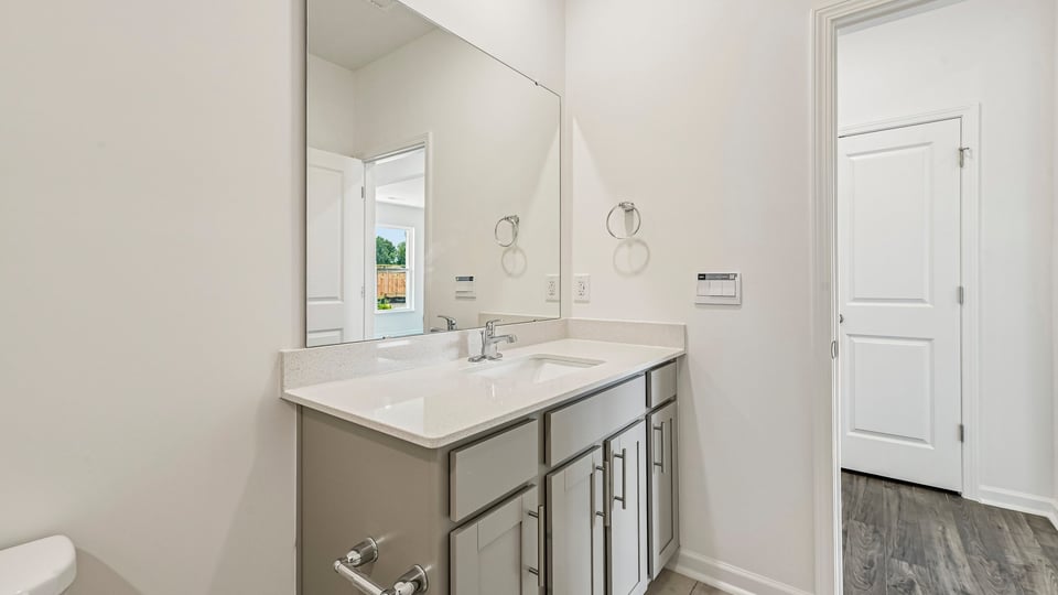bathroom with gray cabinets and quartz countertops