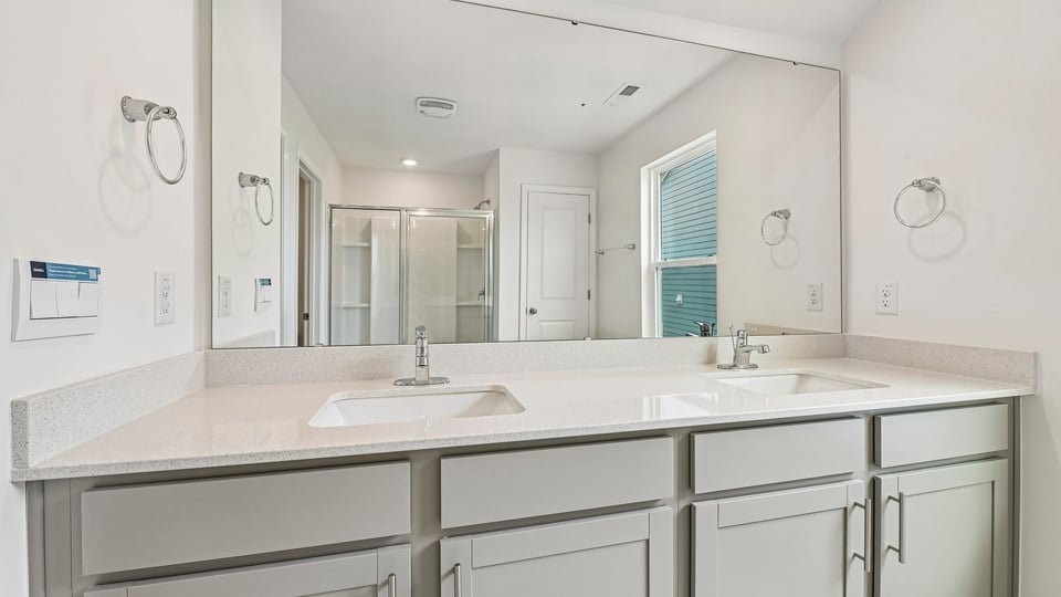 bathroom with dual vanity and quartz countertops