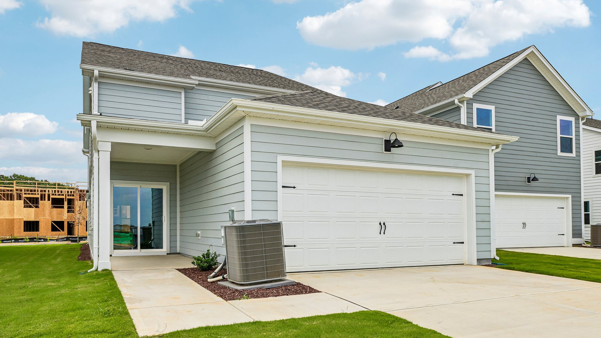 back of home with two car garage and covered patio