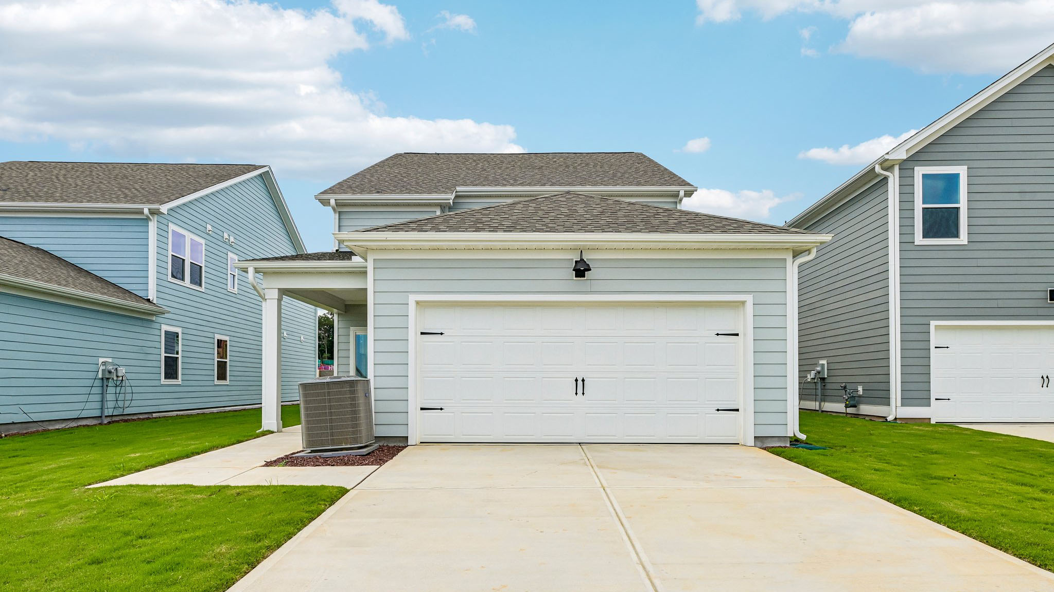 back of home with two car garage and covered patio