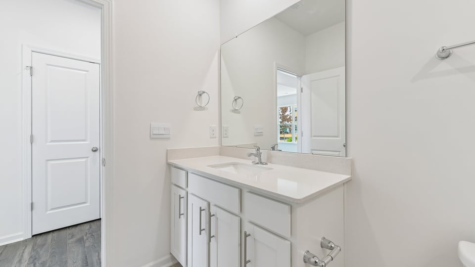 bathroom with white cabinets and quartz countertops