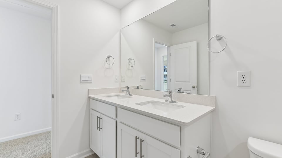 bathroom with white cabinets and quartz countertops