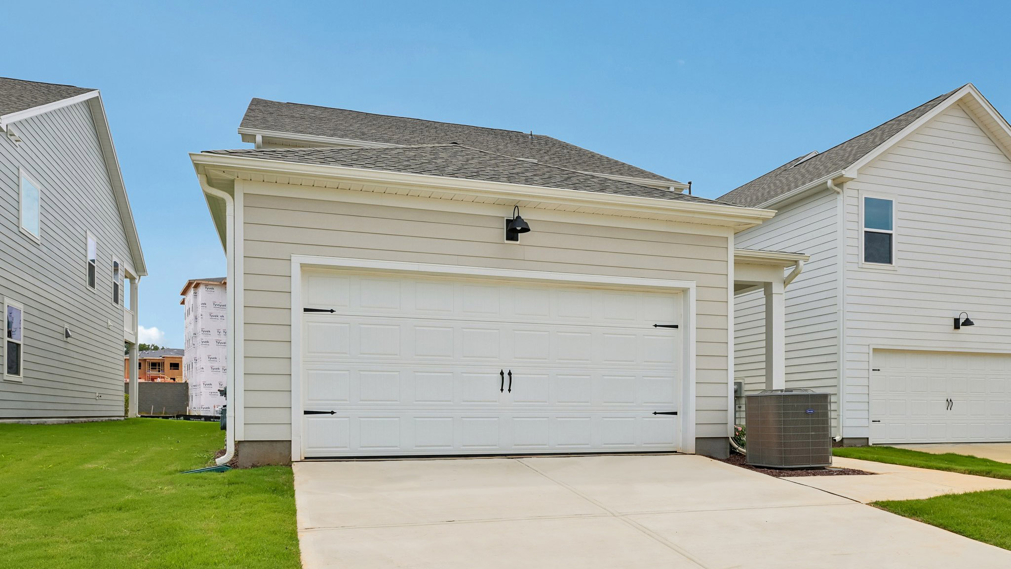 back of home with two car garage and covered patio