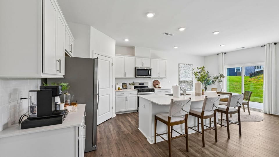 kitchen with spacious island quartz countertops and white cabinest