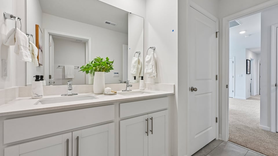 bathroom with dual vanity and quartz countertops