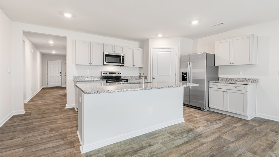 kitchen with quartz counters, kitchen island, pantry, stainless steel appliances