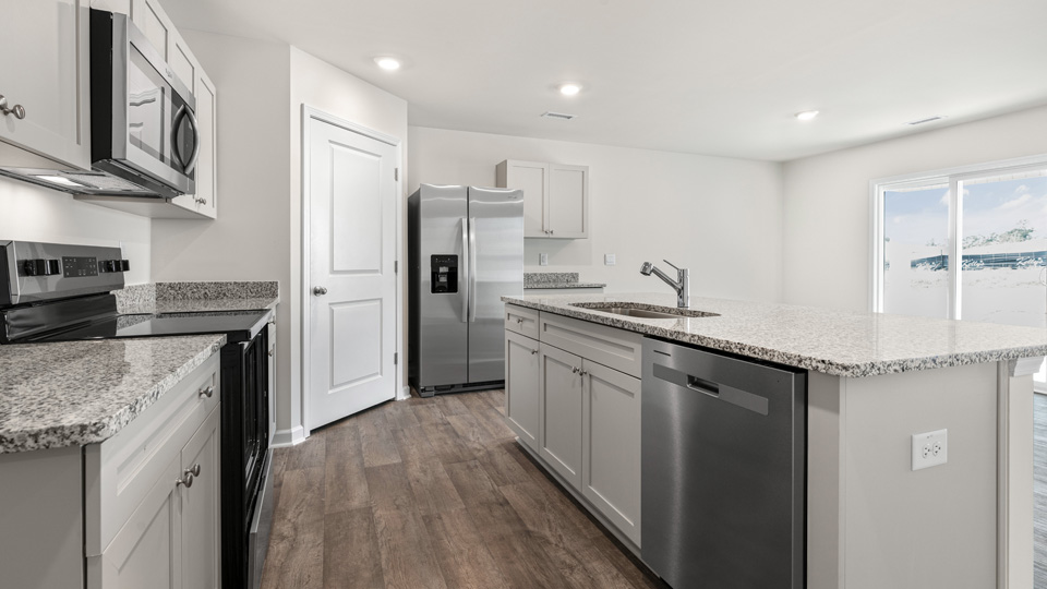 kitchen with quartz counters, kitchen island, pantry, stainless steel appliances