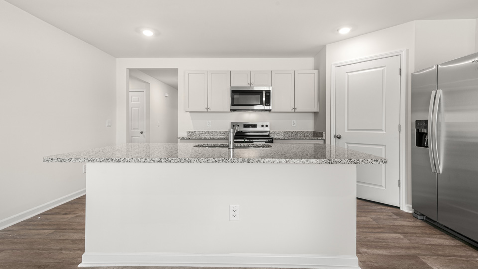 kitchen with quartz counters, kitchen island, pantry, stainless steel appliances