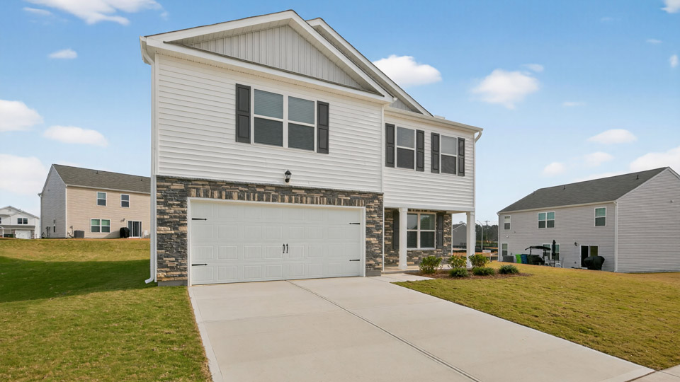 Two story home with white siding and covered porch and two-car garage