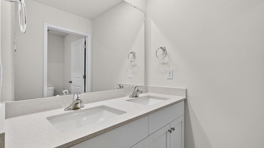 bathroom with white cabinets and quartz countertops