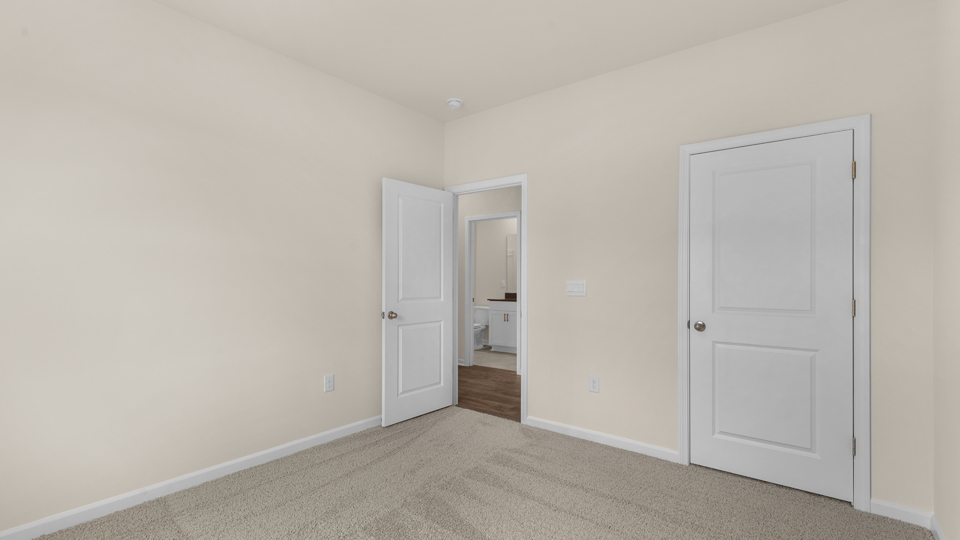 secondary bedroom with window and closet, carpeting