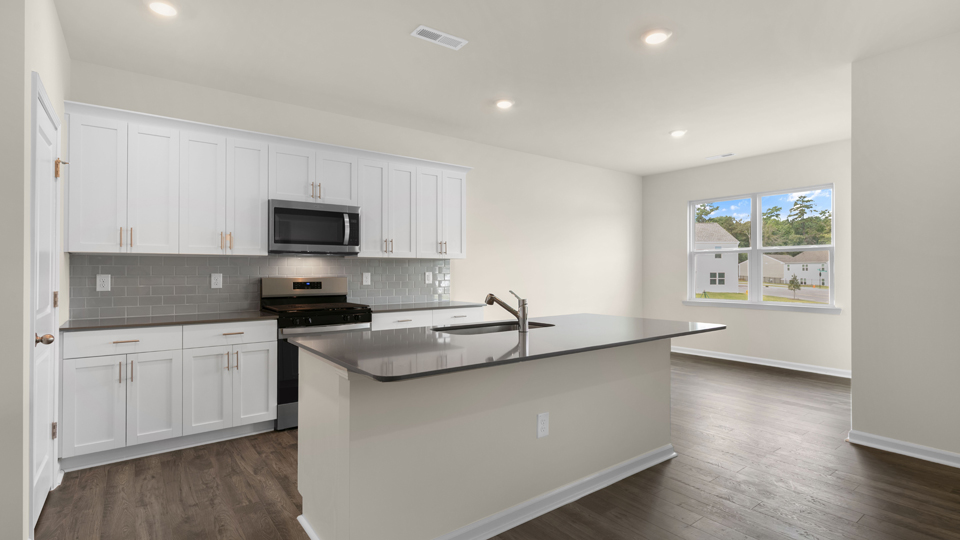 kitchen with quartz counters, kitchen island, pantry, stainless steel appliances