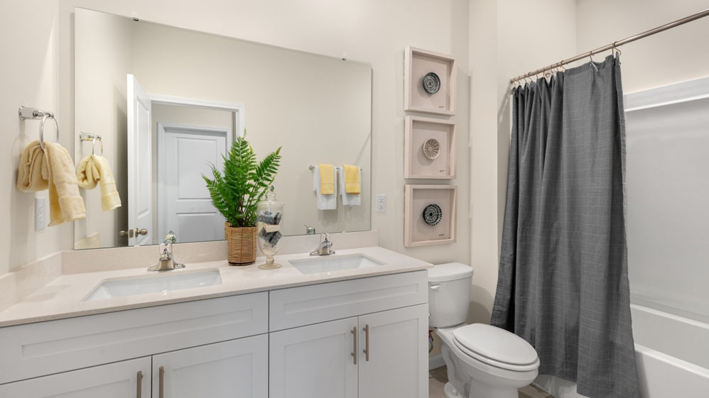 bathroom with tub shower combo and white quartz countertops