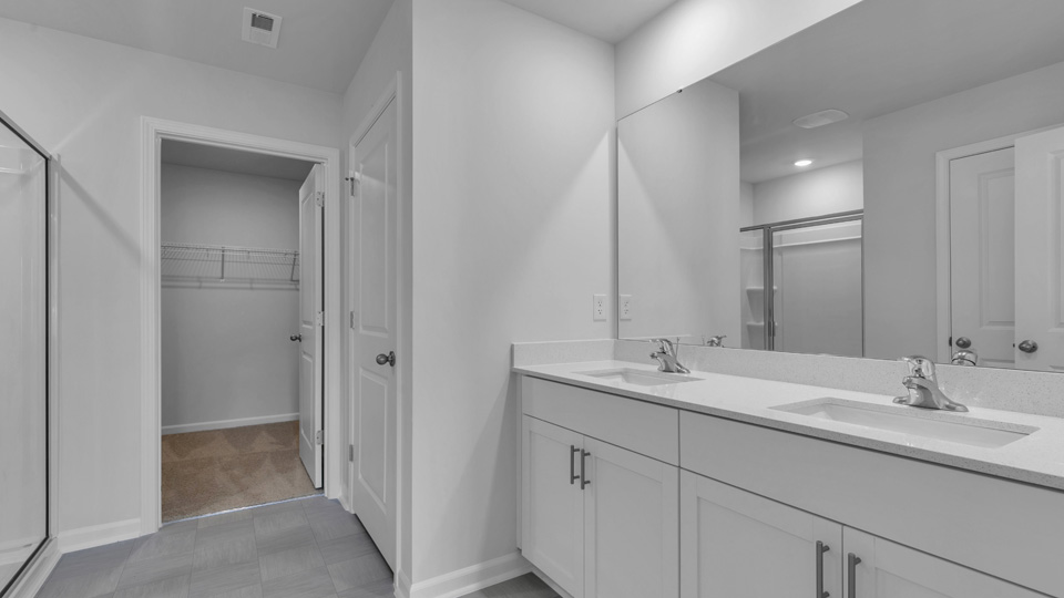 bathroom with dual vanity and walkin closet