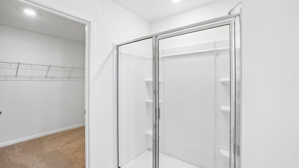 primary bathroom with walk in shower and dual vanity sinks