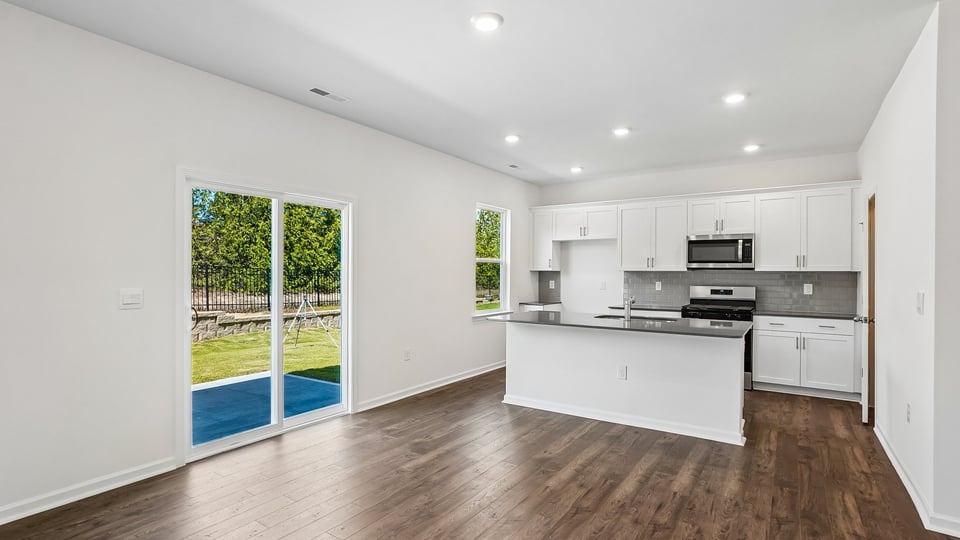kitchen with quartz counters, kitchen island, pantry, stainless steel appliances