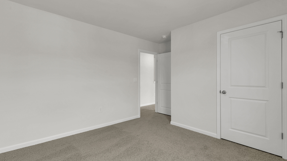secondary bedroom with window and closet, carpeting