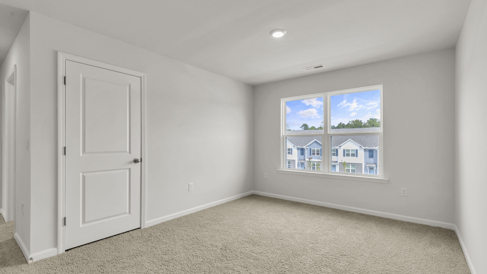 upstairs loft area with large windows and carpeting