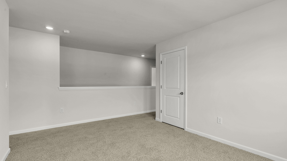 upstairs loft area with large windows and carpeting