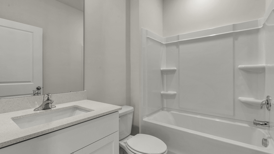 secondary bathroom with walk in shower and single vanity sink