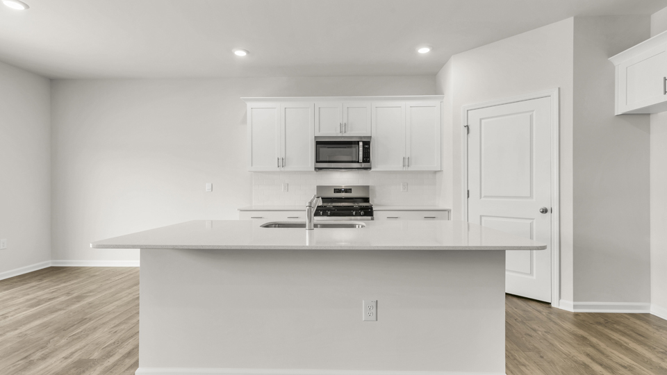 kitchen with quartz counters, kitchen island, pantry, stainless steel appliances