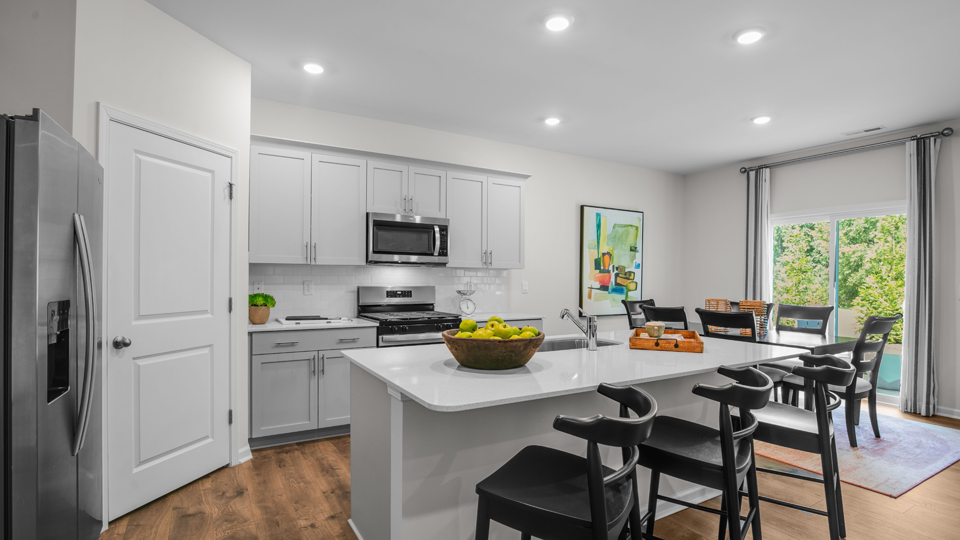 kitchen with quartz counters, kitchen island, pantry, stainless steel appliances