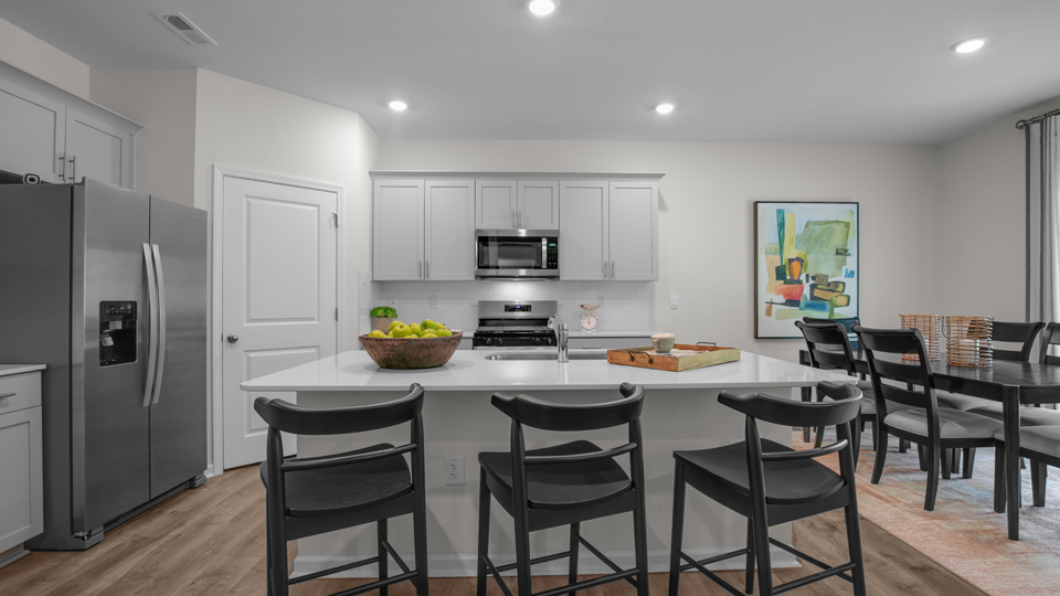 kitchen with quartz counters, kitchen island, pantry, stainless steel appliances