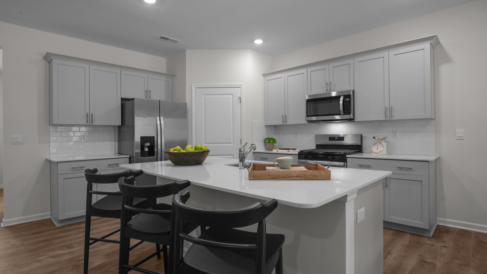 kitchen with quartz counters, kitchen island, pantry, stainless steel appliances