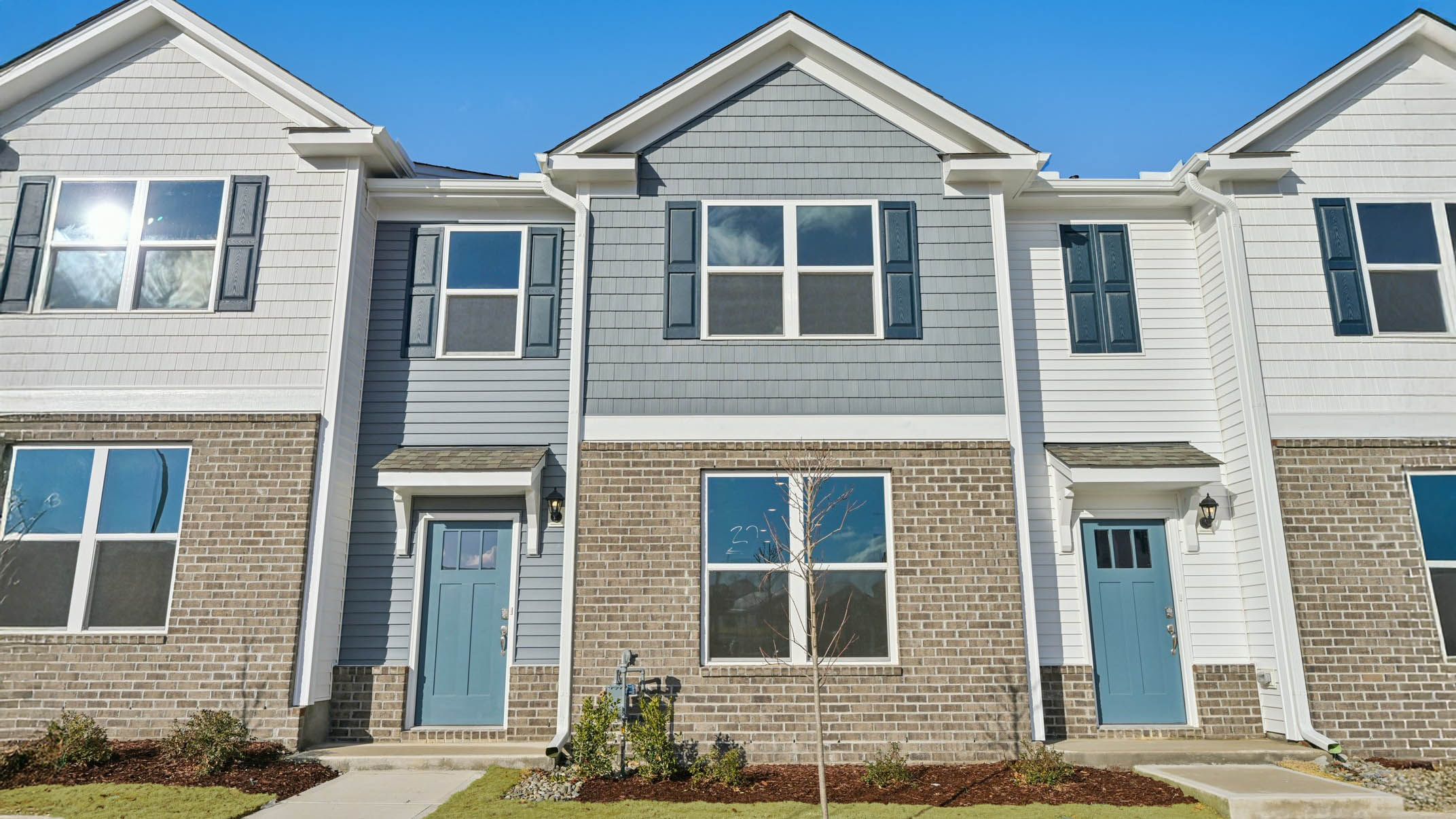 Two story town home with blue siding.