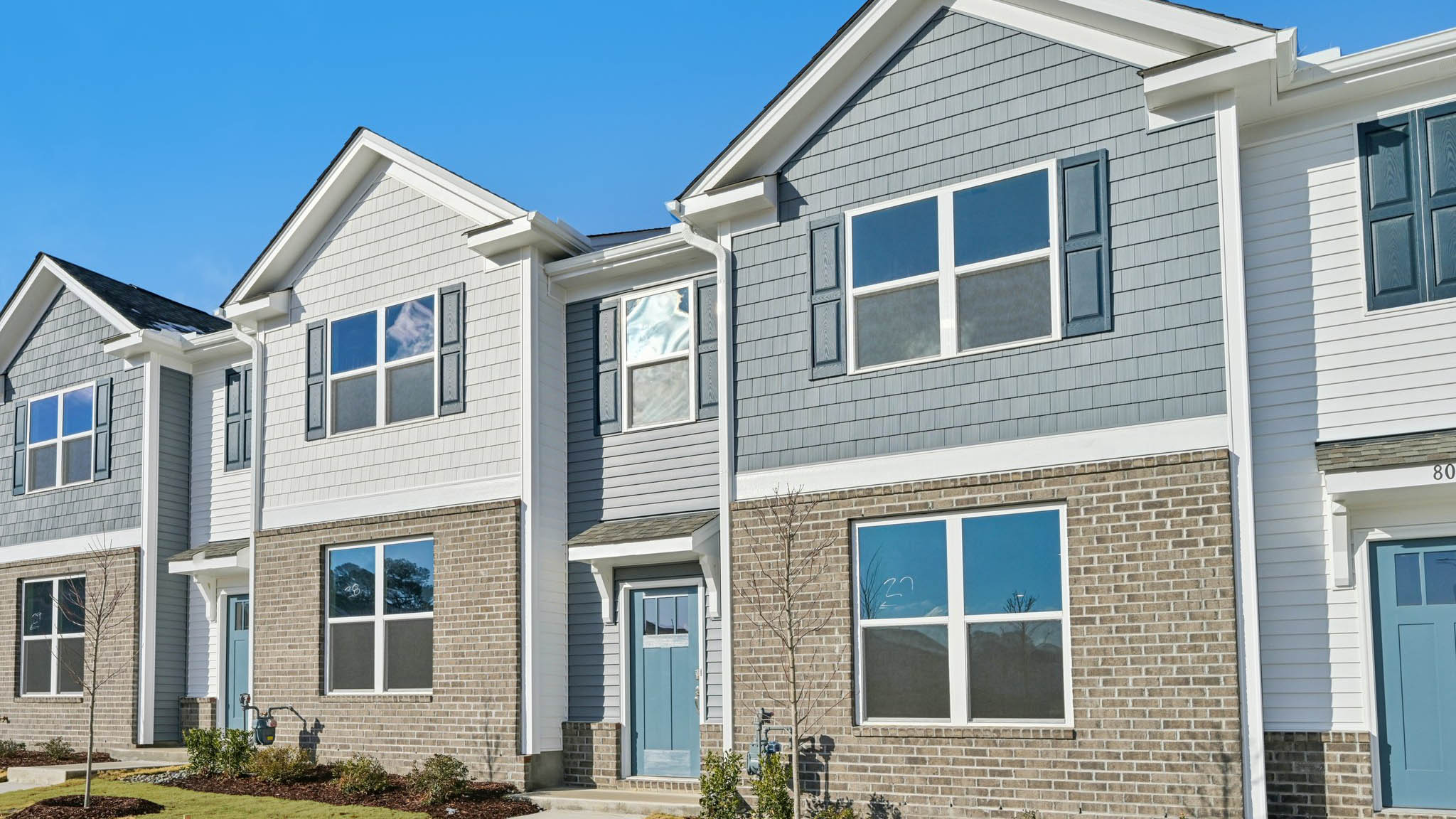 Two story town home with blue siding.