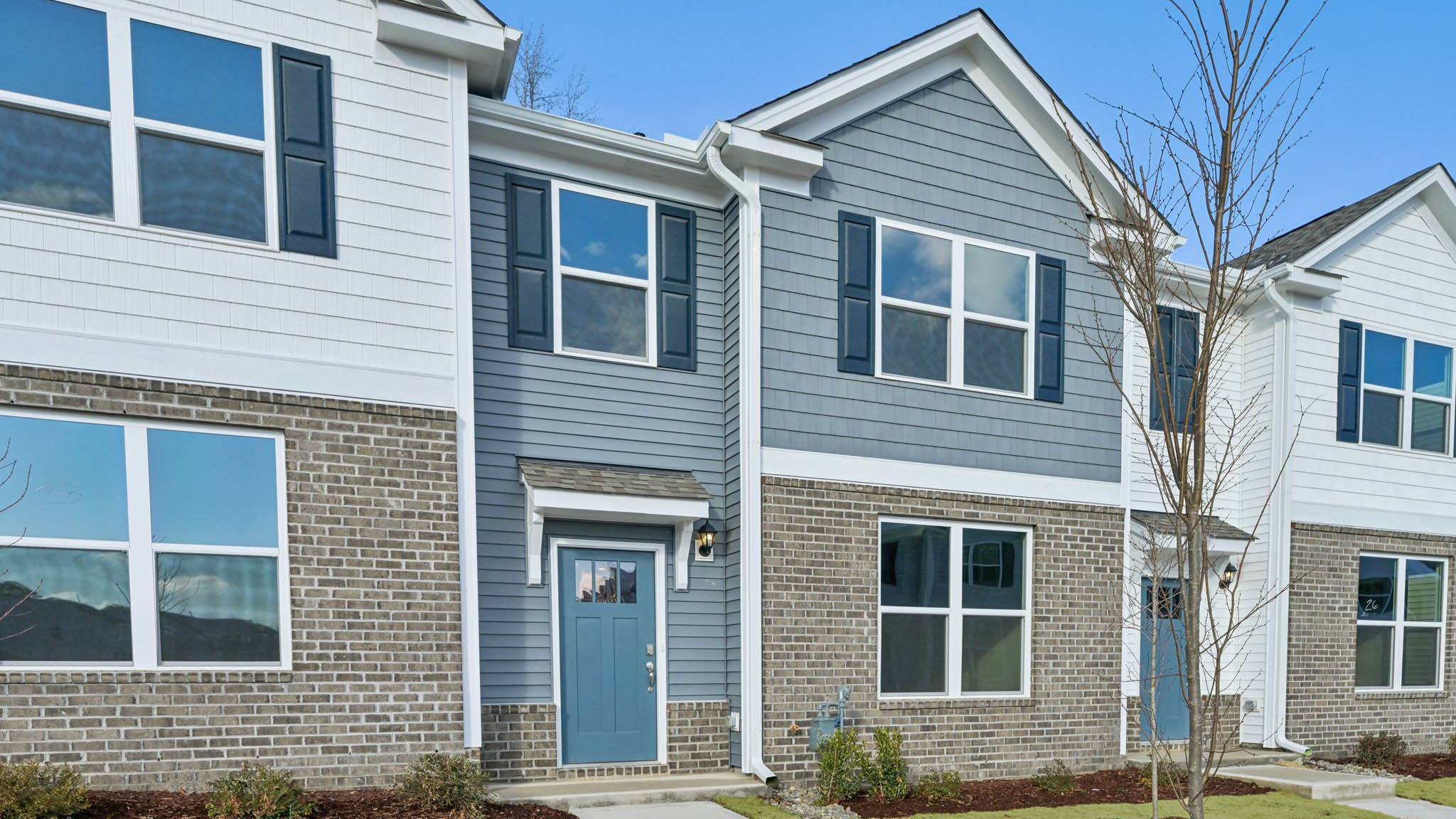 Two story town home with blue siding.