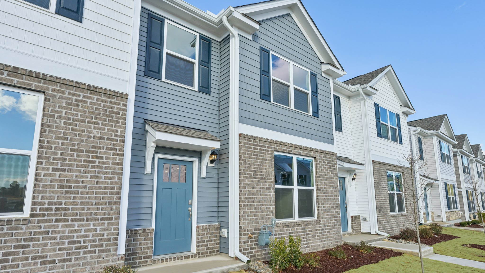 Two story town home with blue siding.