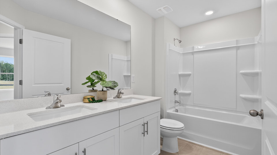 secondary bathroom with shower tub combo and dual vanity sink