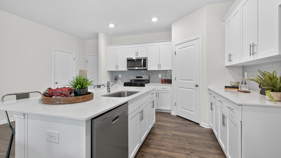 kitchen with quartz counters, kitchen island, pantry, stainless steel appliances