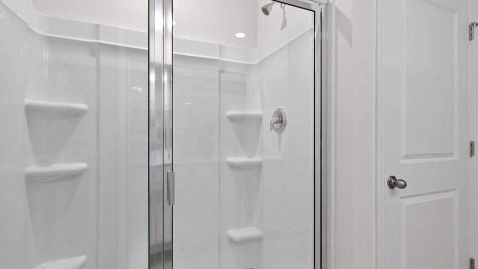 primary bathroom with walk in shower and dual vanity sinks