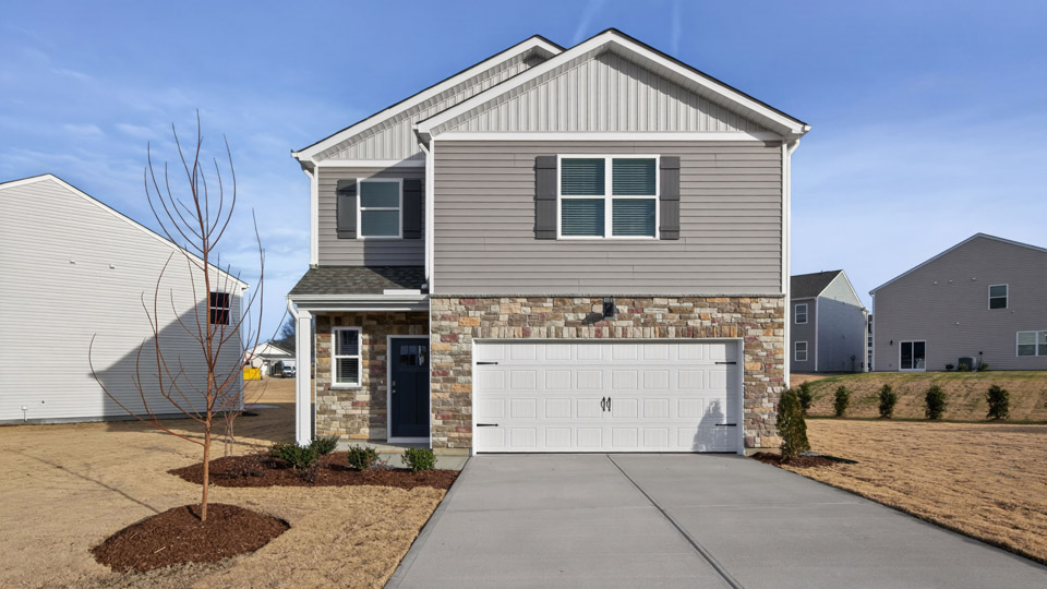 Two story home with gray siding and two-car garage.
