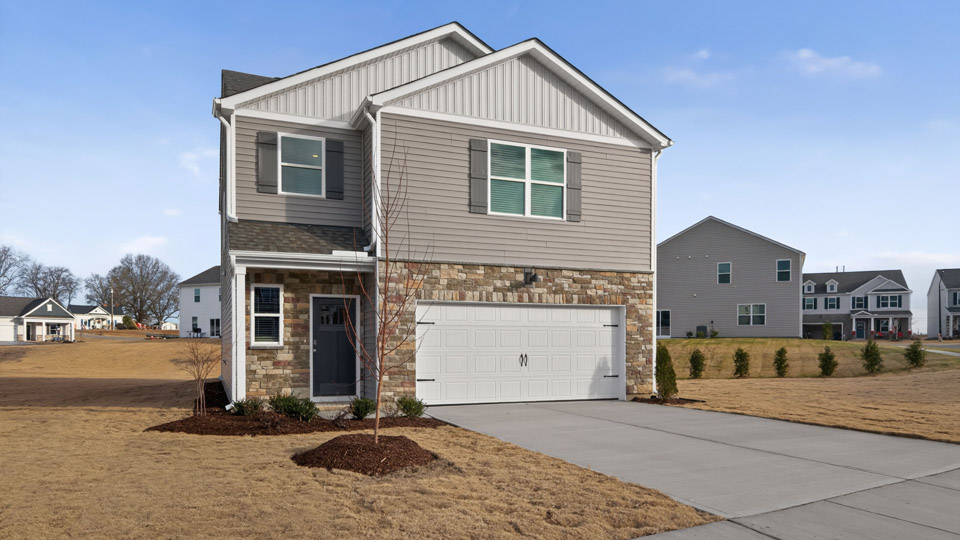 Two story home with gray siding and two-car garage.