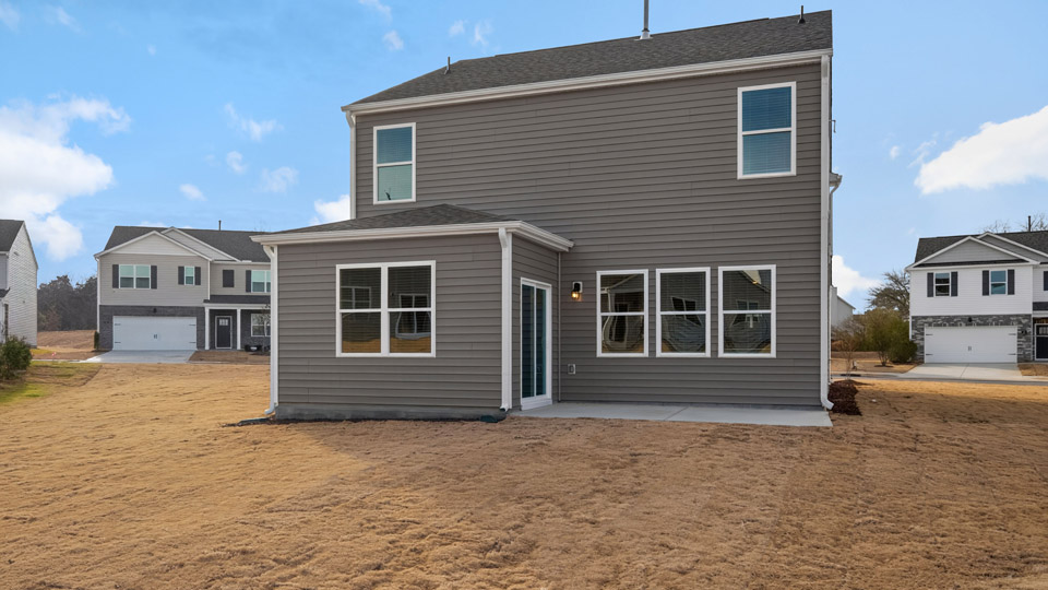 Two story home with gray siding and patio