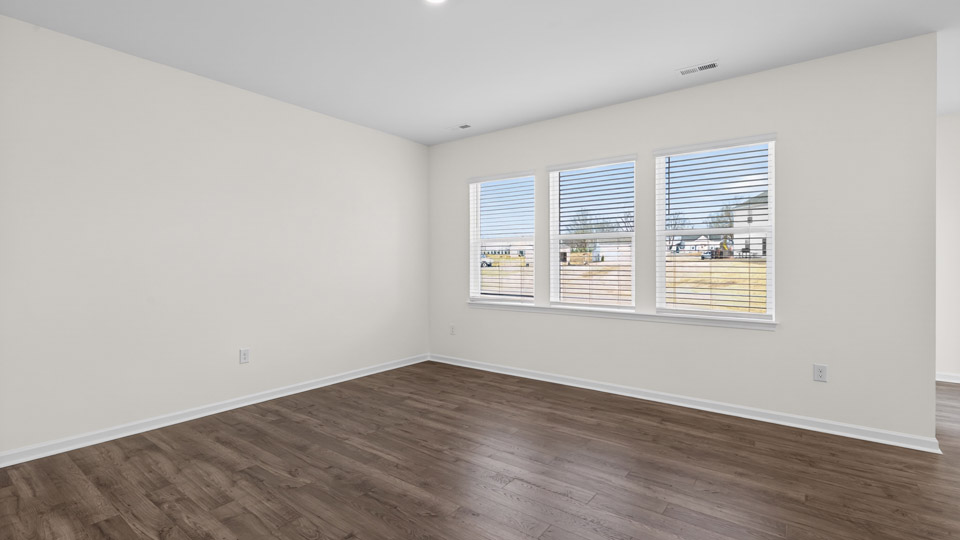Open-concept living room with hardwood floors and large windows