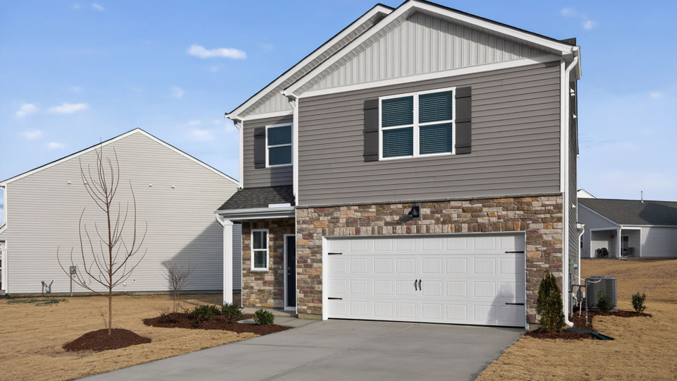Two story home with gray siding and two-car garage.