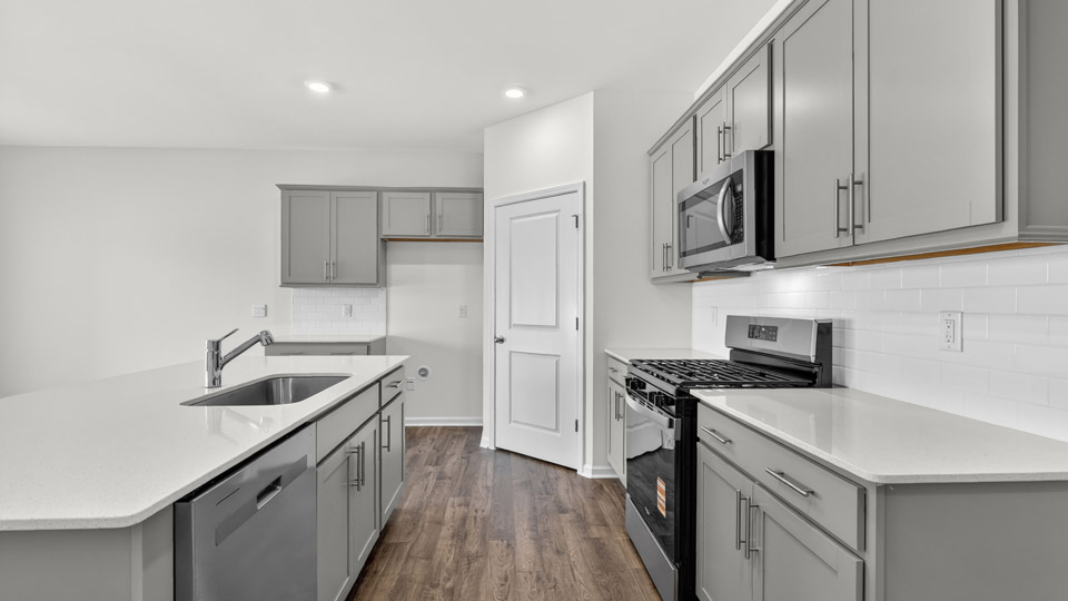 Kitchen with gray cabinets and stainless steel appliances.