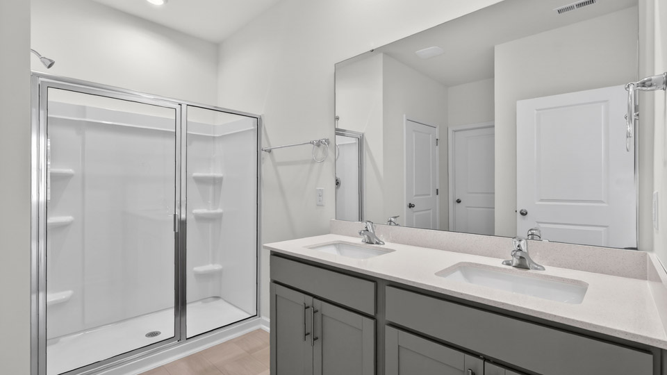 Primary bathroom with double sink and walk-in shower