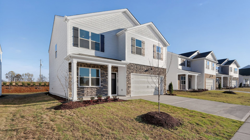 Two story home with white colored siding with a two car garage