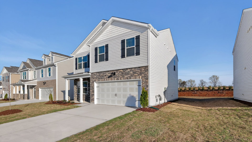 Two story home with white colored siding with a two car garage