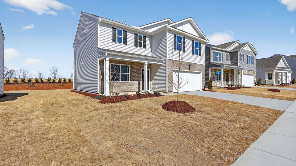 Two story home with gray colored siding with a two car garage