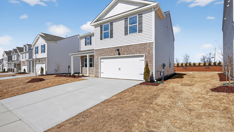 Two story home with gray colored siding with a two car garage