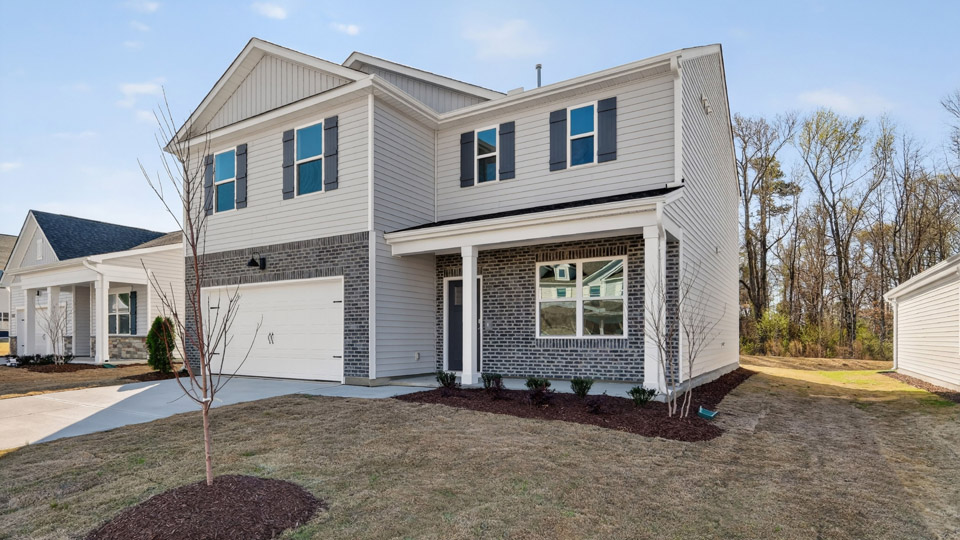 Two story home with white colored siding with a two car garage