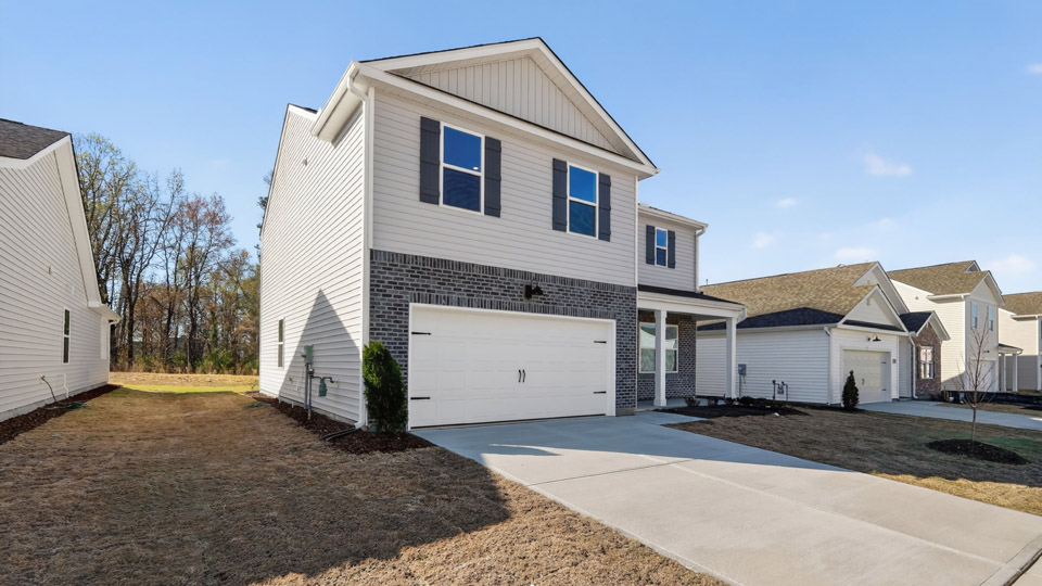Two story home with white colored siding with a two car garage